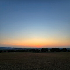 Fototapeta premium The serene sunset over tranquil fields is beautifully captured in its stunning splendor Deister Bad Nenndorf