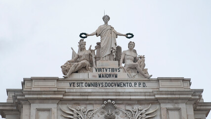 Glory statue standing atop ornate rua augusta arch, bearing laurel wreaths near allegorical figures representing national valor, embodying portuguese historical pride and resilience