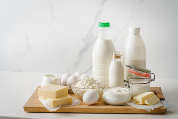 Fresh dairy products, milk, cottage cheese, eggs, yogurt, sour cream and butter on kitchen table