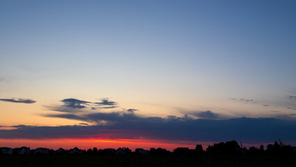 Summer sky sunset over city. Nature, sky with clouds and trees.