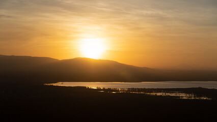 Fototapeta premium Experiencing a Serene and Beautiful Sunset Over Majestic Mountains and a Calm Waterbody Lake Manyara Tanzania Africa
