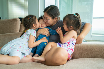 A woman is holding a baby and two young girls.