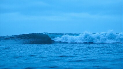 Fototapeta premium Powerful ocean wave cresting with deep blue hues symbolizing resilience