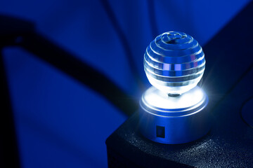 Small rotating disco ball in motion blur as effect light for nightlife events like club, disco or party, dark blue background, copy space, selected focus