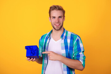 Birthday gift. Party on mens day. Mens day. Birthday party present. Man pointing finger. Young guy hold present box for Valentines day. Happy anniversary. Man with gift isolated on yellow