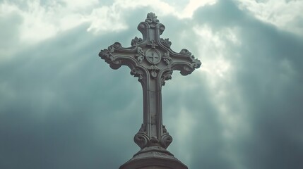 Ornate stone cross against a dramatic, cloudy sky.  Sunlight breaks through the clouds, illuminating the intricate details of the religious symbol.
