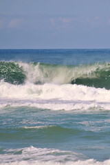 Blue and green ocean waves on sunny day. Scene of natural ocean beauty and coastal landscape.
