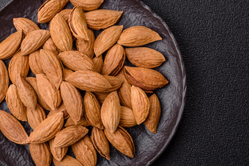 Roasted or raw almond nuts in shell in bowl