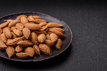 Roasted or raw almond nuts in shell in bowl