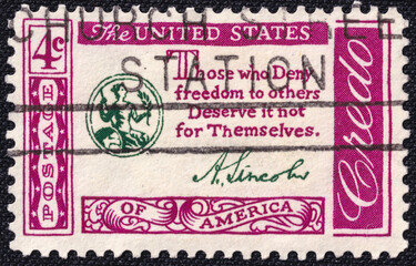 U.S. stamp issued in 1954 featuring a quote from Abraham Lincoln: "Those who deny freedom to others deserve it not for themselves." Ornamental border with patriotic design.
