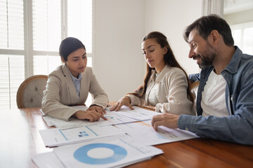 Real estate financial advisor and couple of customers planning investment for new property buying,...