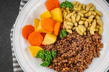Lentils and vegetables vegetarian main course, bean, potatoe, carrot tasty fresh gourmet food background on the table rustic food top view copy space keto and paleo diet vegetarian and vegan food
