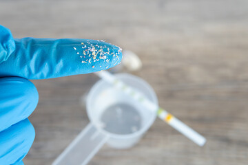 research on microplastic particles in water sample in laboratory with water and PH test. contamination and damage by microplastics in people.