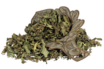 peppermint tea leaves in a rusty tea strainer isolated on white background