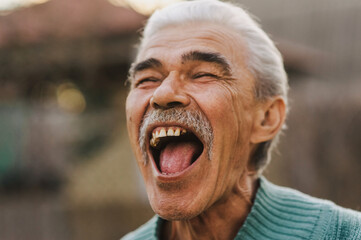 Photograph, close-up portrait of a cheerful, laughing old gray-haired man, an elderly pensioner...