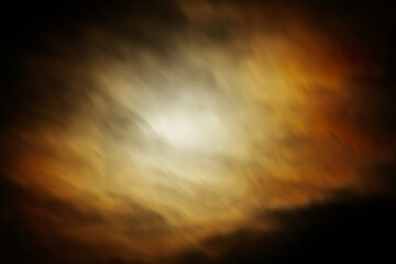  surreal night sky with an intense glow behind dark, swirling clouds. The dramatic mix of warm and...