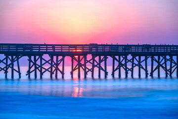Sunrise over the pier at Isle of Palms, SC, USA.