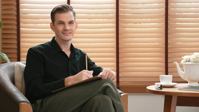 Male psychologist man sitting on arm chair in psychiatrist office or therapy room. Friendly and professional mental healthcare counselor and therapist. Adit