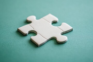 Obraz premium A single white puzzle piece resting on a teal surface