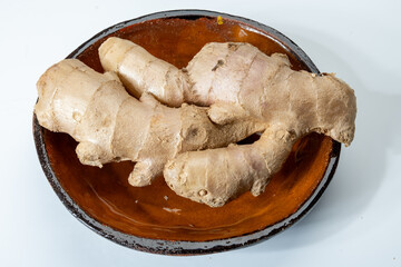 Fresh organic ginger rhizome root used in traditional medicines and for flavoring meals, drinks, isolated on white
