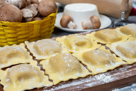 Italian food, fresh home made stuffed pasta ravioli dumplings with ricotta soft cheese and champignons porcini mushrooms, Parma, Emilia Romagna, Italy