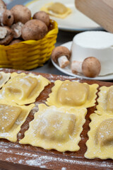 Italian food, fresh home made stuffed pasta ravioli dumplings with ricotta soft cheese and champignons porcini mushrooms, Parma, Emilia Romagna, Italy