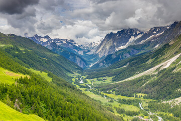 Fototapeta premium Beautiful mountain landscape of the Alps in summer on tour du Montblanc area near Courmayeur village in Val Ferret valley in Italy. European Alps stunning views of green valley with colorful flowers