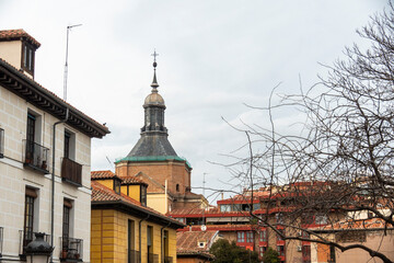 A church tower can be seen positioned between two structures in a city