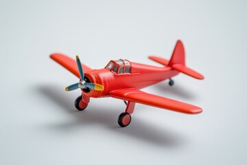 A small red toy airplane with blue and yellow propeller blades