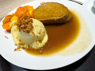 Savory meatloaf with mashed potatoes and carrots in rich brown gravy