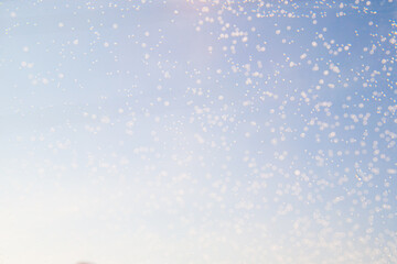 Bubble reflections twinkling in the sunlight against a clear blue sky