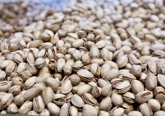 A lot of selected in the shell delicious pistachios for sale in a box at a local specialty market. Close-up