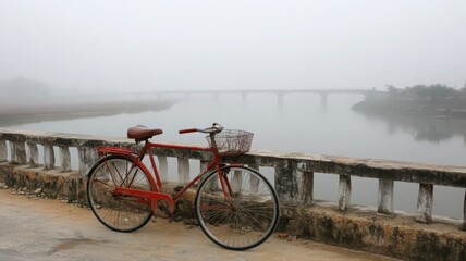 Fototapeta premium Red Bicycle on Foggy River Bridge