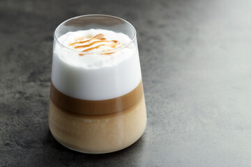 Tasty latte macchiato in glass on grey table, closeup. Space for text