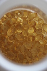 Omega 3 background from fish oil closeup. Vitamins soft capsules. Cod liver oil. Concept of healthcare, supplements, vitamin D
