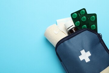 Obraz premium First aid kit on light blue background, top view. Space for text