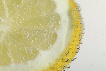 Soda water with lemon slice as background, closeup