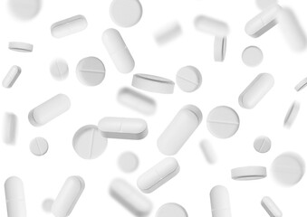 Many different pills flying on white background