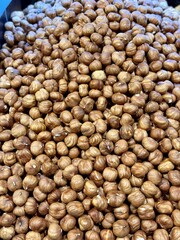 The kernels of peeled hazelnuts on the counter at the market, put up for sale at the supermarket's vegetable stand, showcases organic products, vegetarian food, and healthy food. Close-up