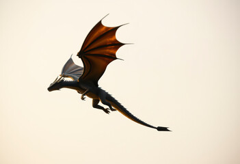 A dragon flies gracefully against a plain background, showcasing its incredible wingspan and fierce features while navigating the skies.