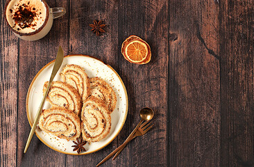 Modern bakery concept, Homemade delicious dessert, sponge cake or roll with sweet jam, cream, nuts and cinnamon and eggnog filling. Festive treat and advertising for cafe and restaurant