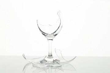 Pieces of broken wine glass on table against white background