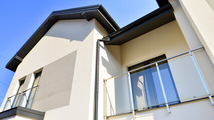 The real estate market in the suburbs. New single family houses in a new development area. Residential homes with modern facade. Terraced family homes in newly developed housing estate. 