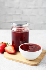 Delicious strawberry sauce and fresh berries on light table