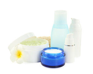 Different body care products and plumeria flower isolated on white