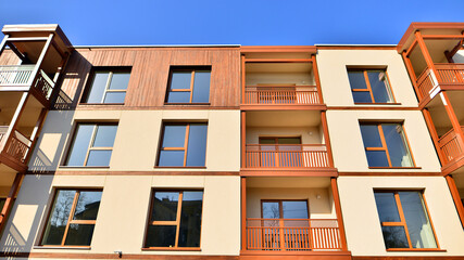 New apartment building. Residential area with modern apartment building. in sunny day. Fragments of the wooden facade.