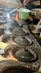 A seller pouring a batter made from coconut milk at traditional process of cooking 