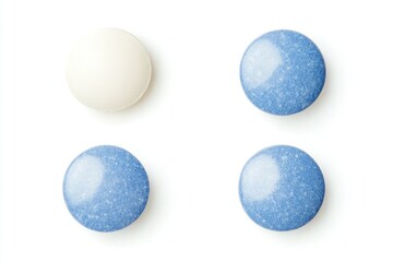 Two light blue and two white round candies on white background