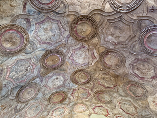Pompeii, Campania, Italy - July 6, 2024: Ancient Roman City ruins on Via Dell' Abbondanza. Terme Stabiane building, the Stabian Baths. Detail of ceiling decorations