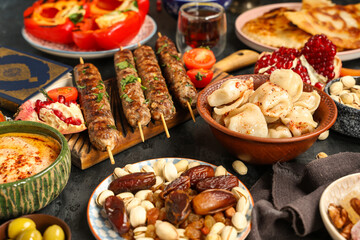 Different traditional Eastern dishes on black table. Ramadan celebration
